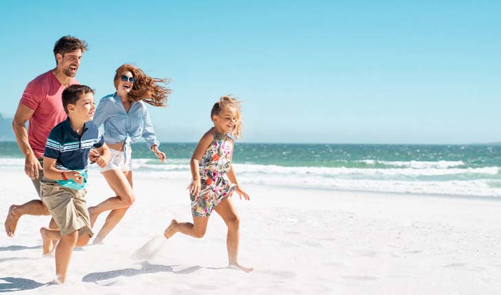 family running along the beach